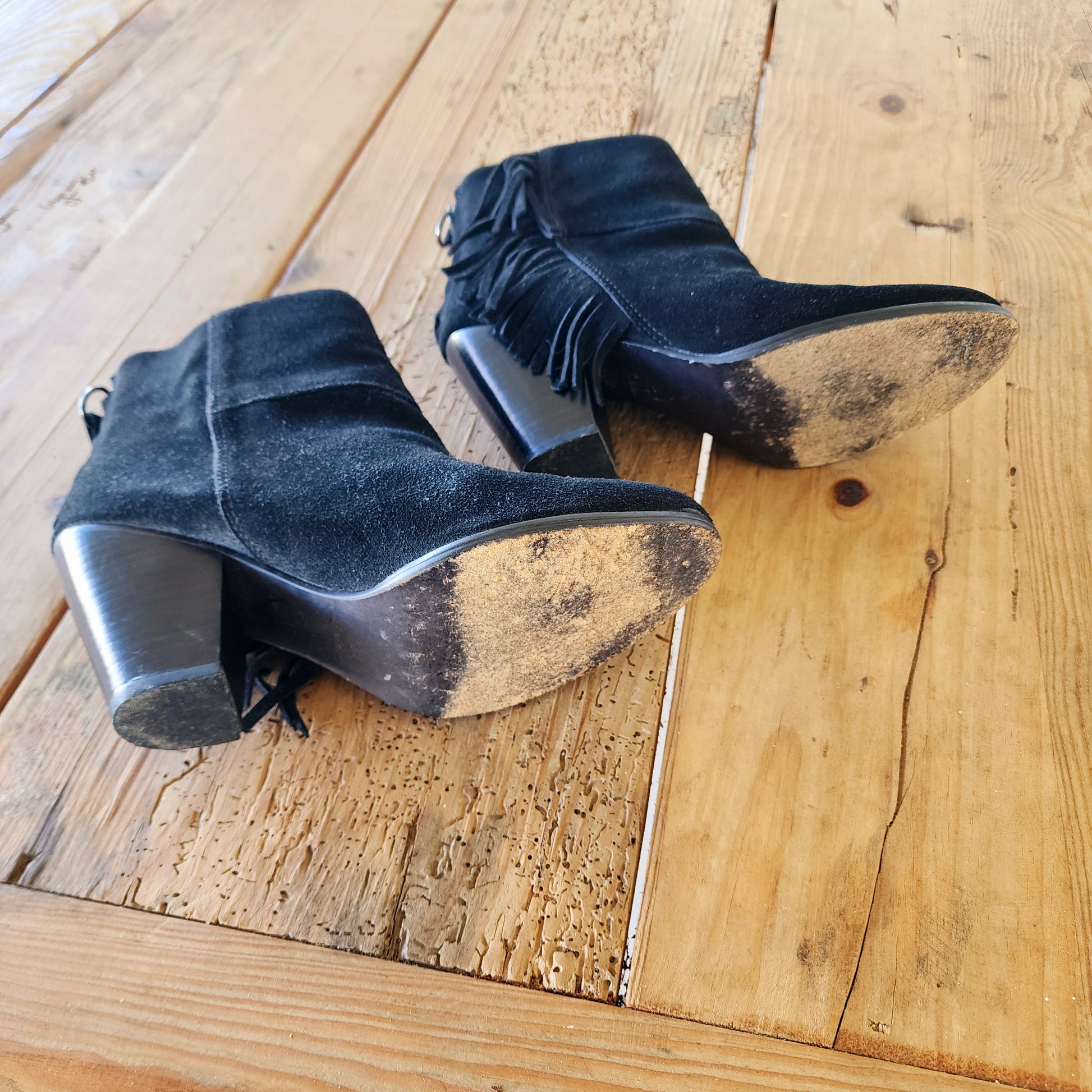 Bottom view of the Ash fringe suede boots, showing the signs of wear on the bottom of the boots and heel