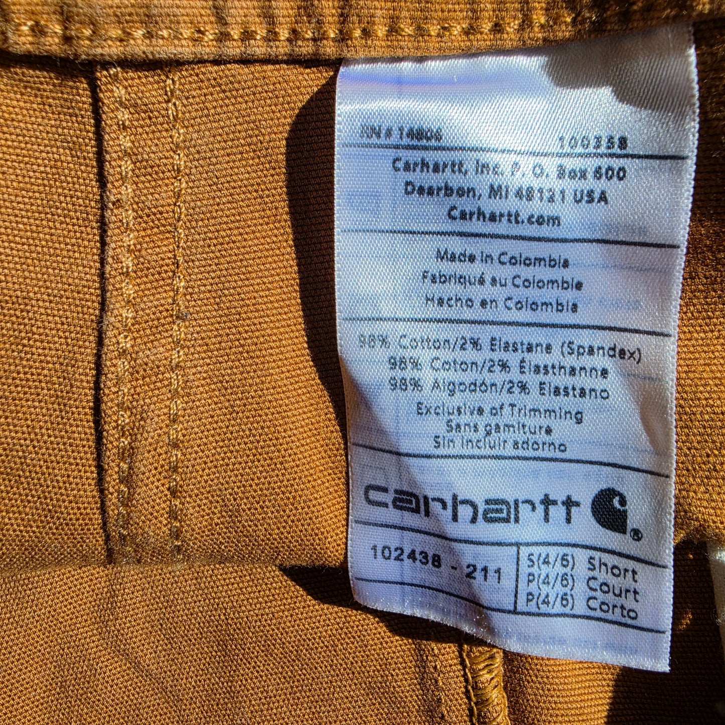 Close-up of a Carhartt label on the mustard overalls