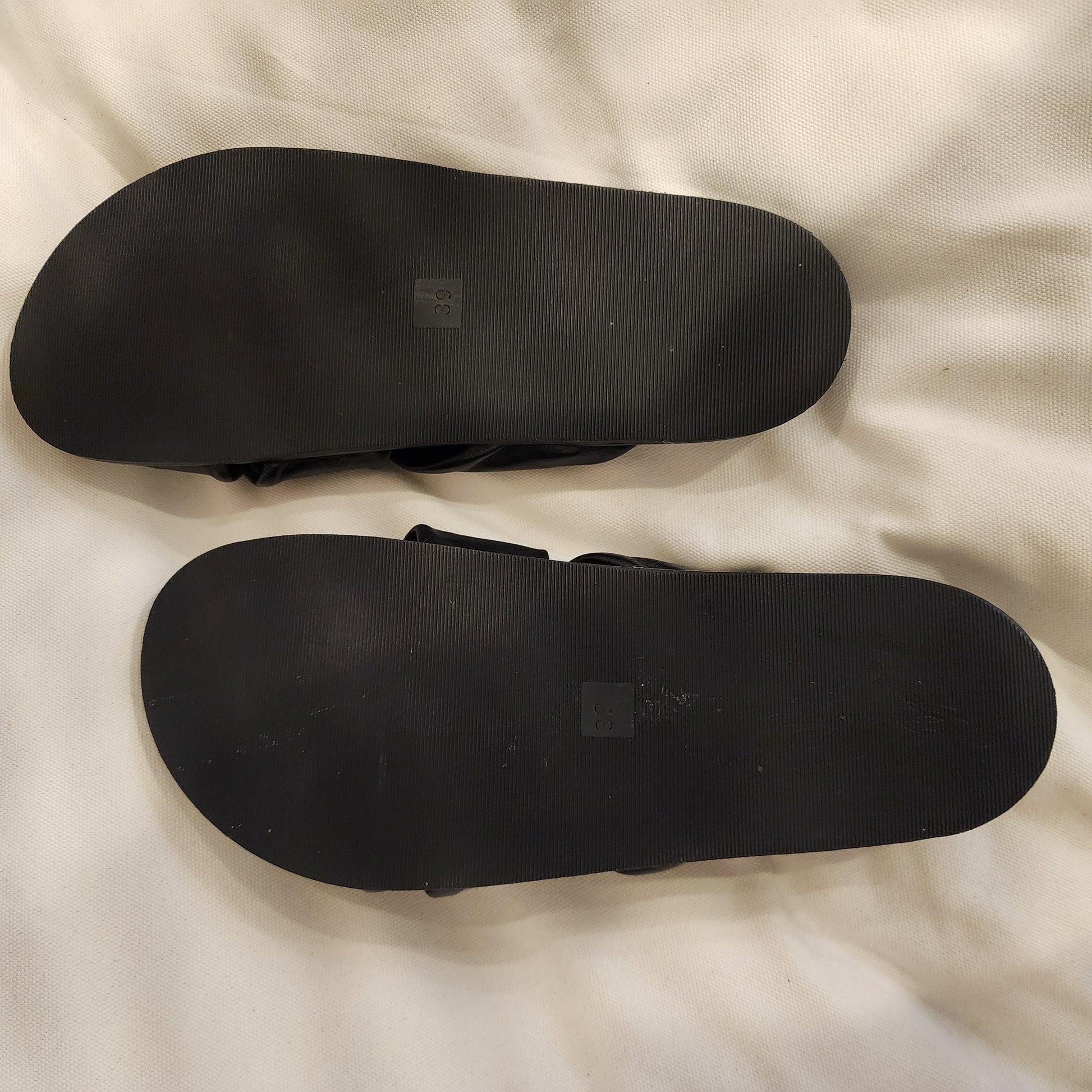 Bottom view of Carvela slides showing black rubber soles with size 39 imprint, minor signs of gentle wear
