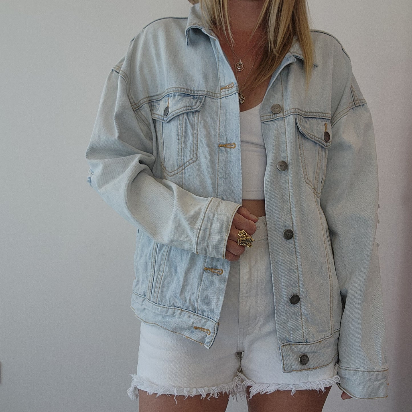Front view of RVCA denim jacket styled with shorts and a crop top, showing classic button-up design and relaxed fit. Size S