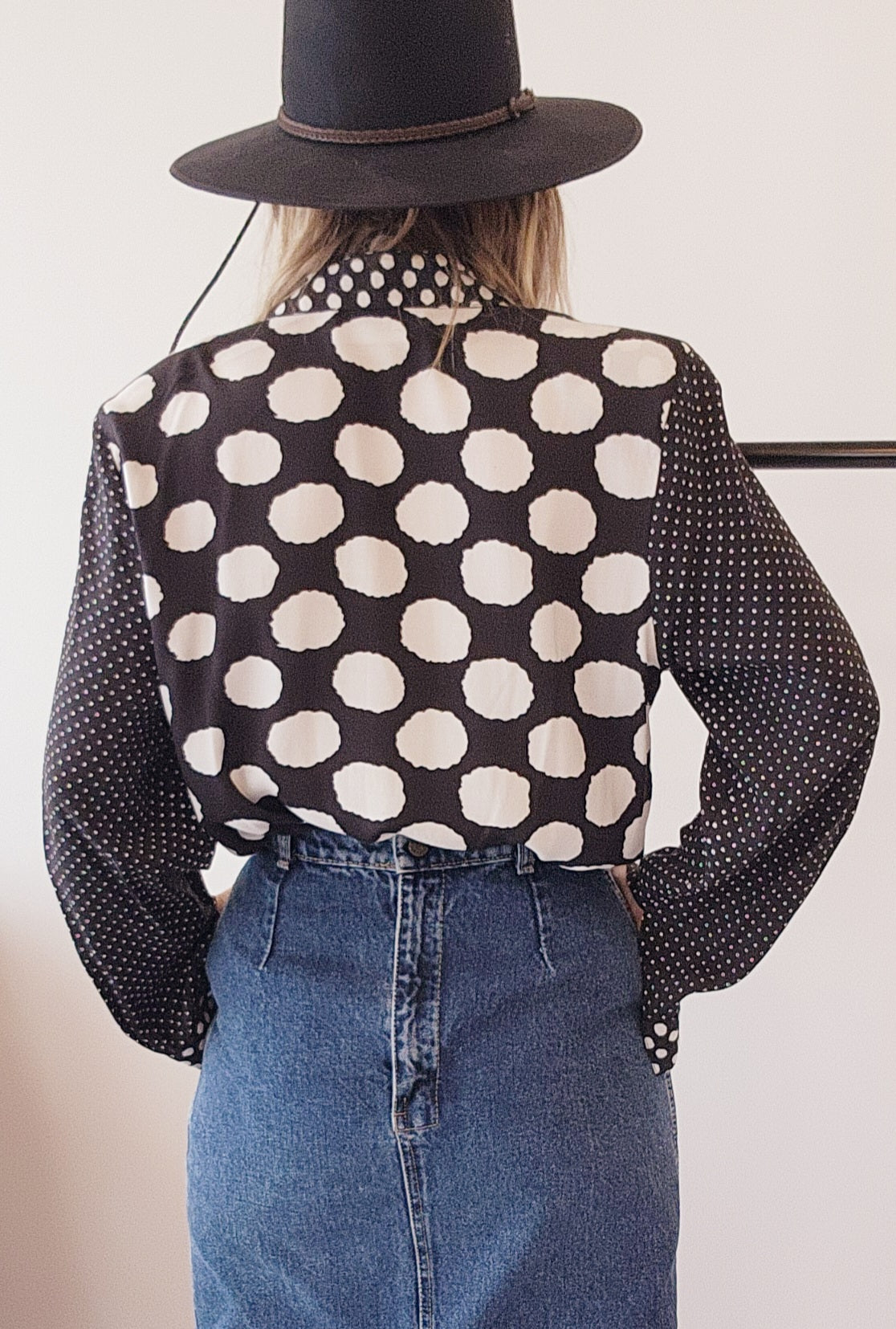 Side profile of model wearing patterned button-up vintage shirt, showing relaxed fit and long sleeves.