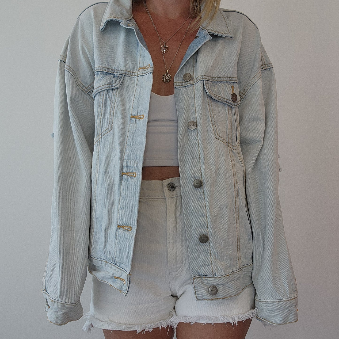 Front view of RVCA denim jacket styled with shorts and a crop top, showing classic button-up design and relaxed fit. Size S