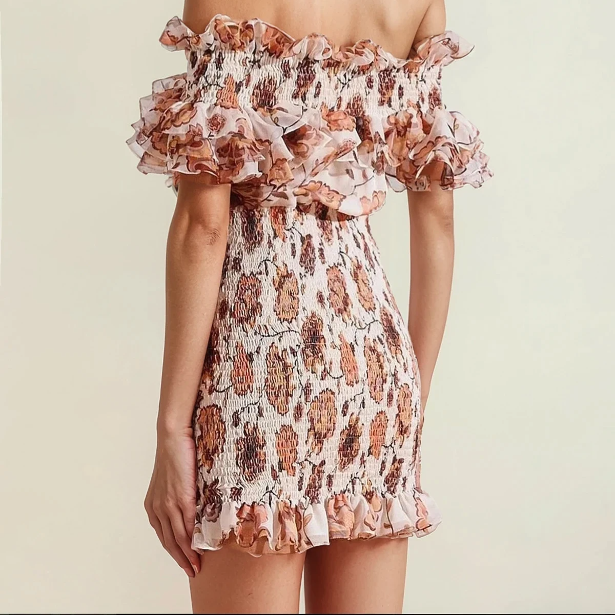 Model showing the side view of the floral Shona Joy Baez mini dress in earthy florals, with frill neckline, hemline and sleeves.