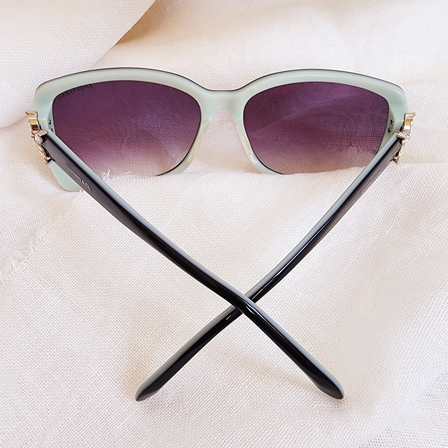 Close up of the back of the Authentic Tiffany & Co. sunglasses, showing the aqua inside of frame, gradient lens and placement of Swarovski crystal temple details.