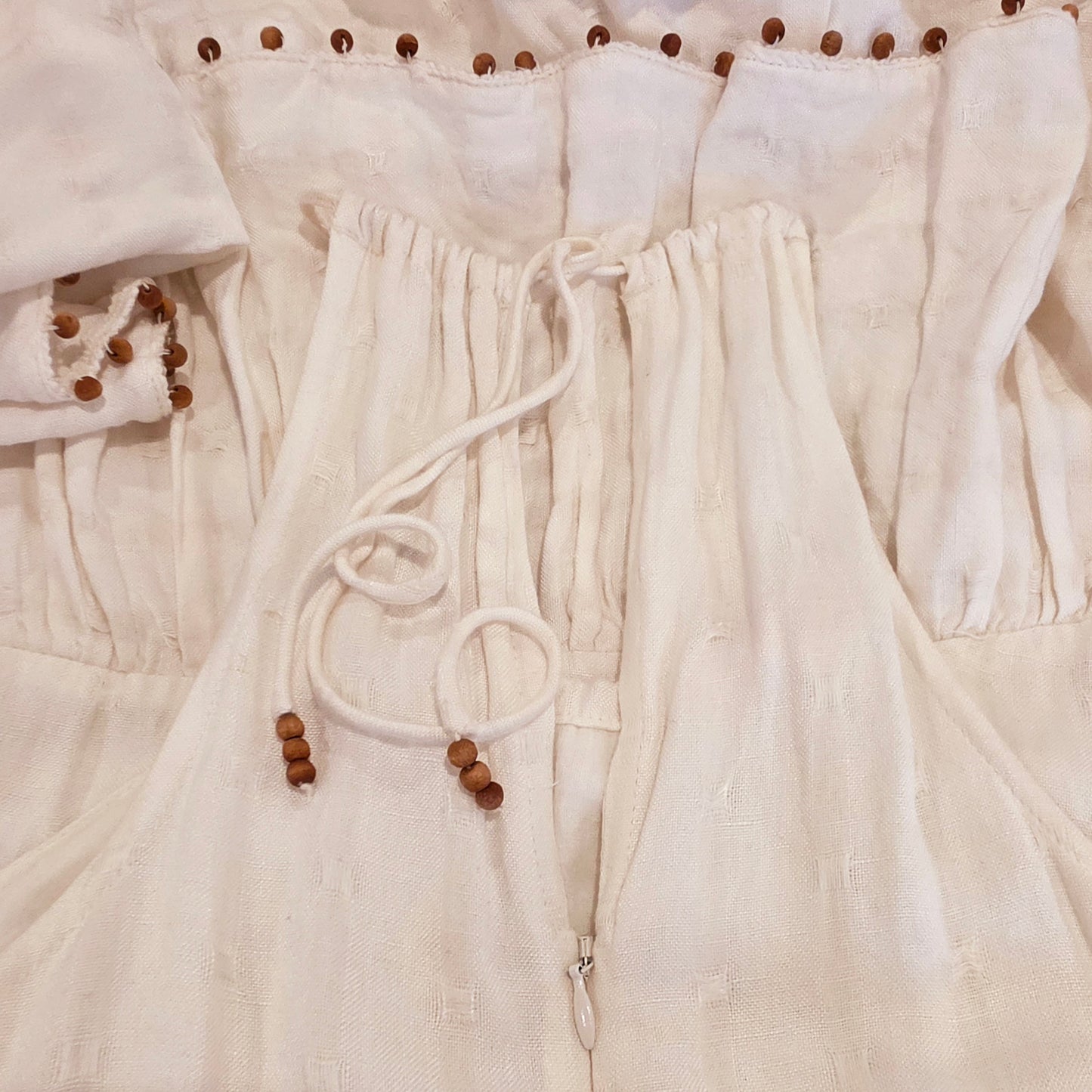 Close up of the the back o f the Tigerlily Avari Midi dress showing the zip up back and adjustable tie neckline with beaded details.