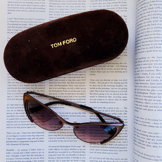 Tom Ford Natasya sunglasses in rose bronze and case on a magazine background.