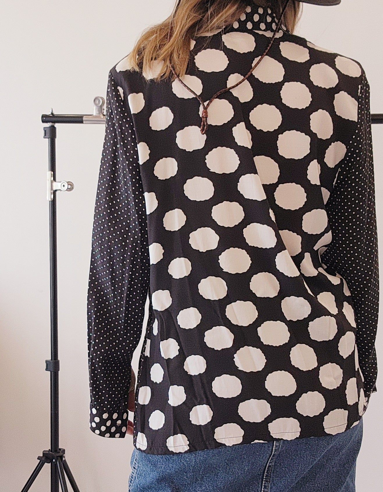 Back view of 90s multi-pattern shirt with shoulder pads, highlighting the mix print of abstract and polka dots.