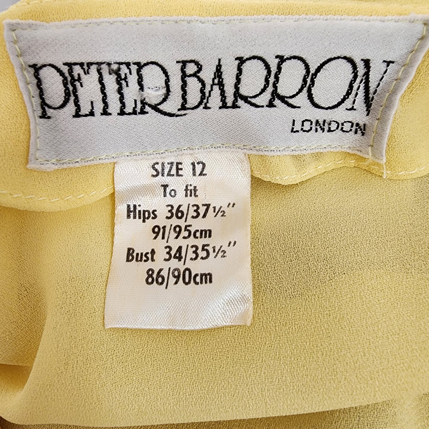 Lemon yellow semi-sheer Vintage Peter Barron dress in a size 12. This dress has a white & Yellow ruffle neckline and a fabric tie belt. Available online now at Wilsonavenue.au