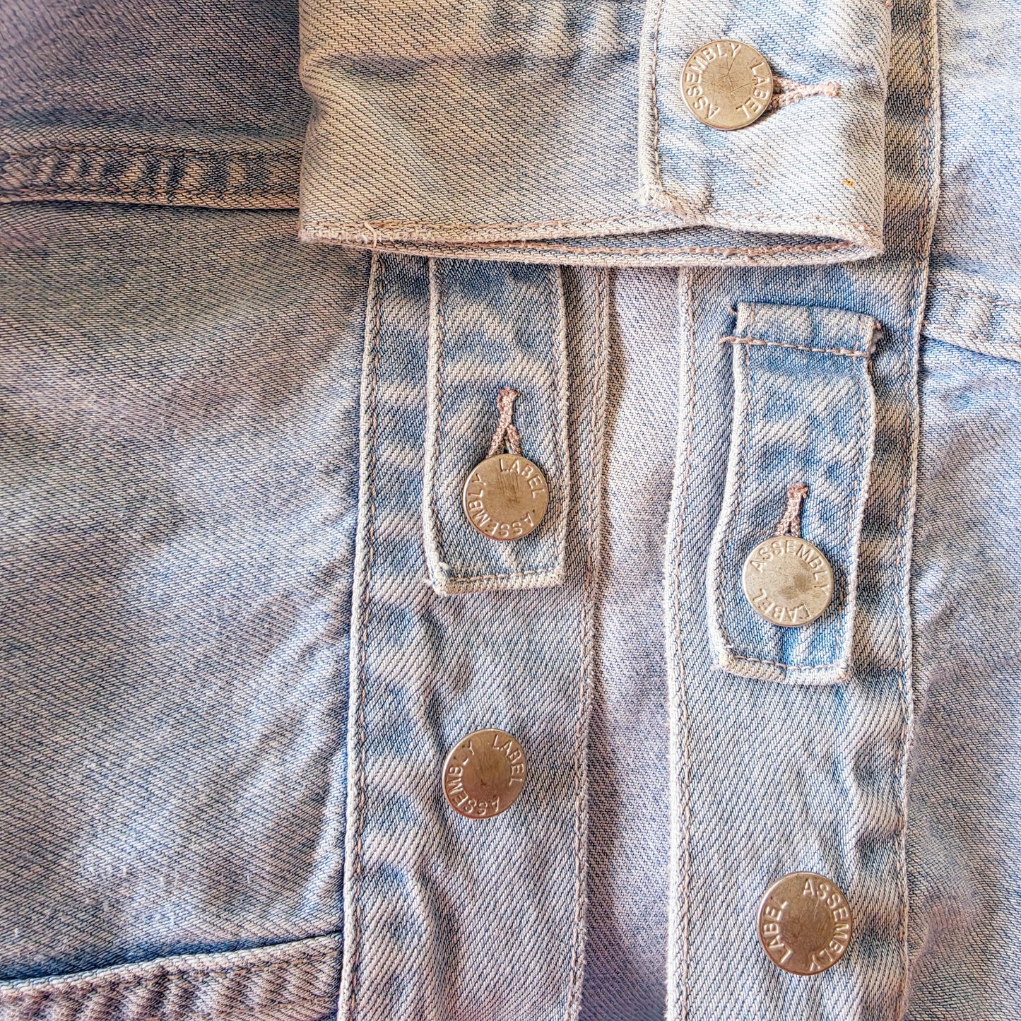Close up view of the Assembly Label denim jacket showing the slight wear to the buttons.