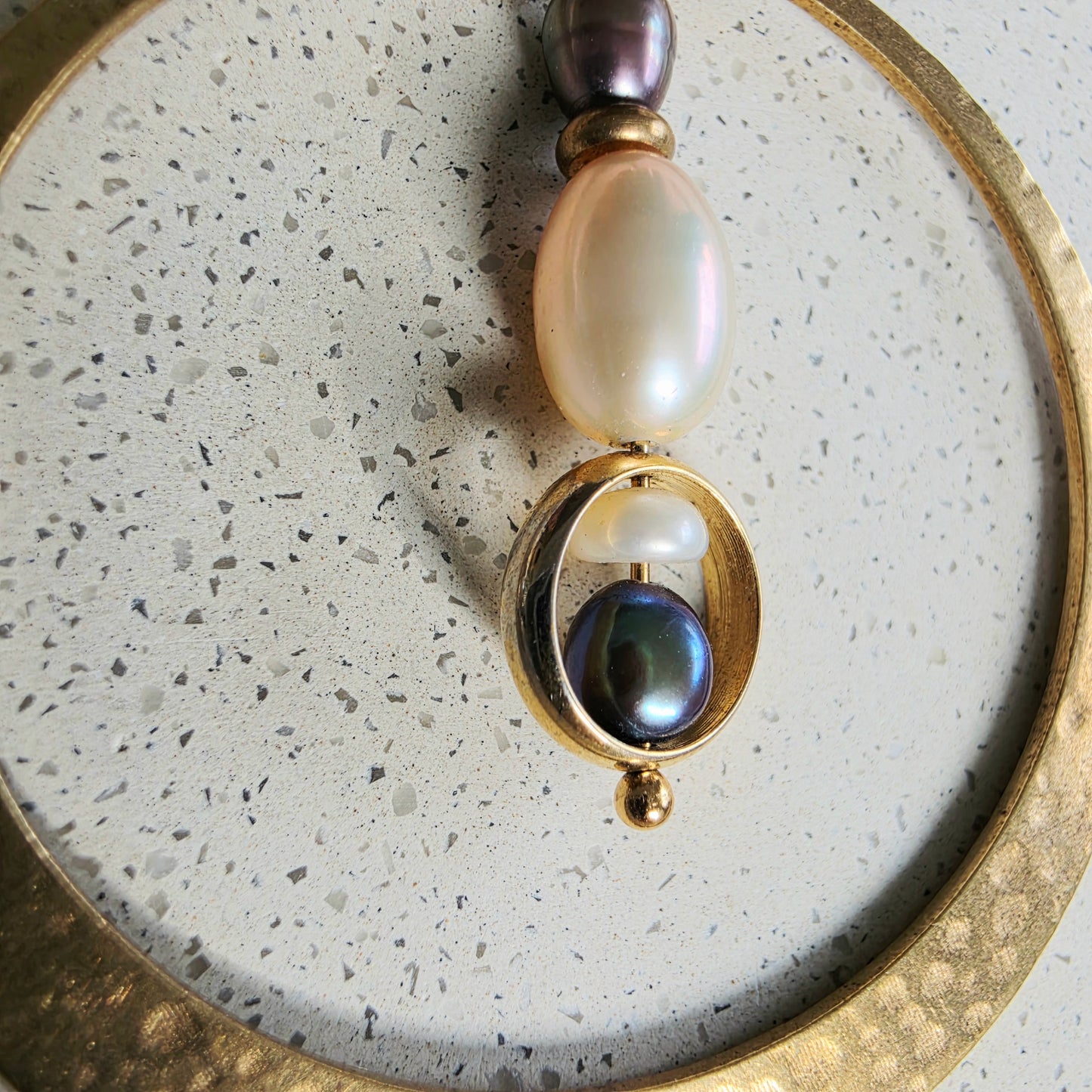 Close up view of the gold smaller round component, showing the gold colour slightly rubbing off the recycled piece.