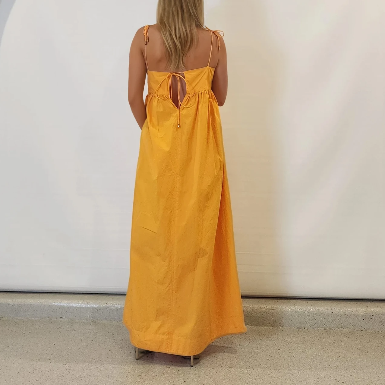 Back view of the Daisy Says marigold midi, showing tie-back and flowy silhouette.