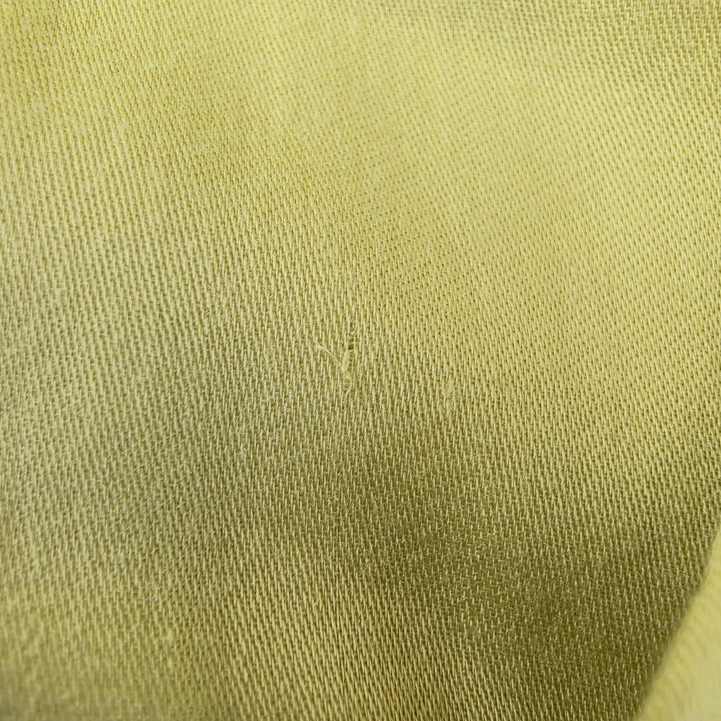 Close up view of the small pull in fabric on the inside lining of the Eva Kayan citrus coloured midi dress.