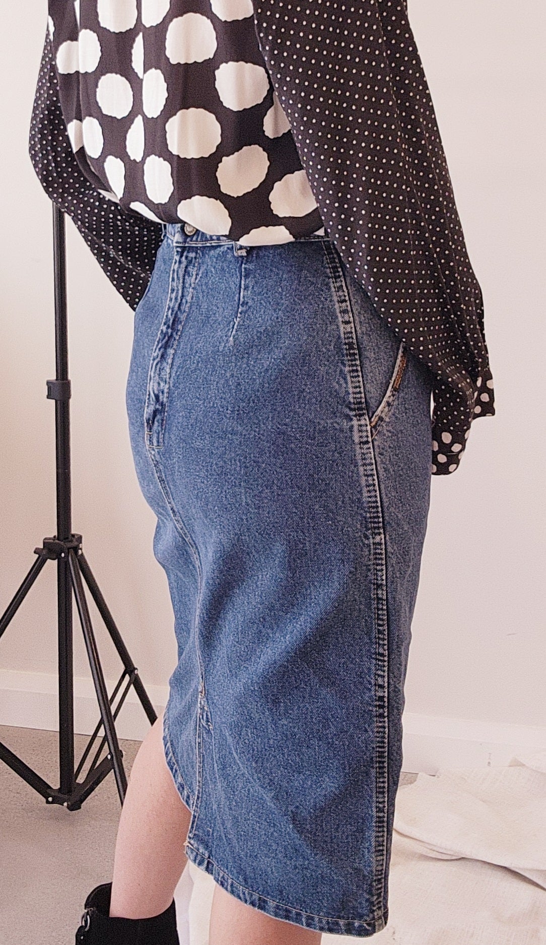 Vintage 80's denim skirt by Faberge. Classic style with front pleats and pockets. Knee length skirt with zip up back and button in a size 8.