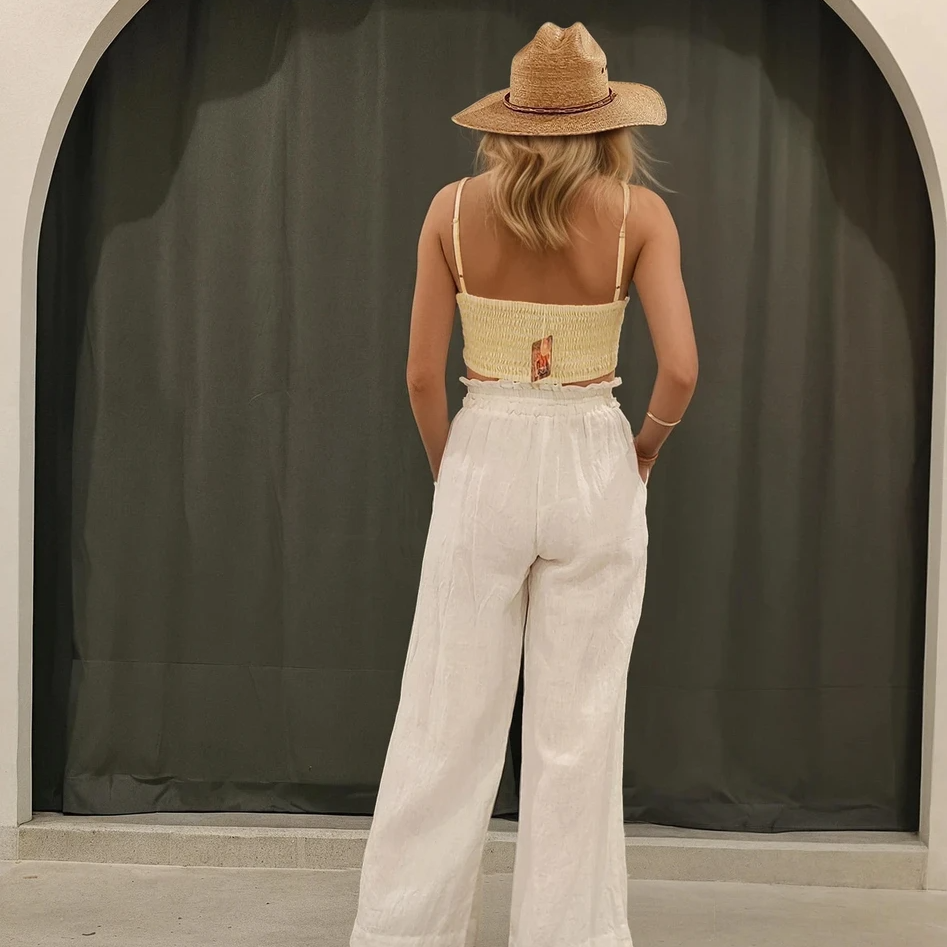 Back view of the Garnier Top showing back shirred detail and square cut, styled with Kivari Linen pants and hat.