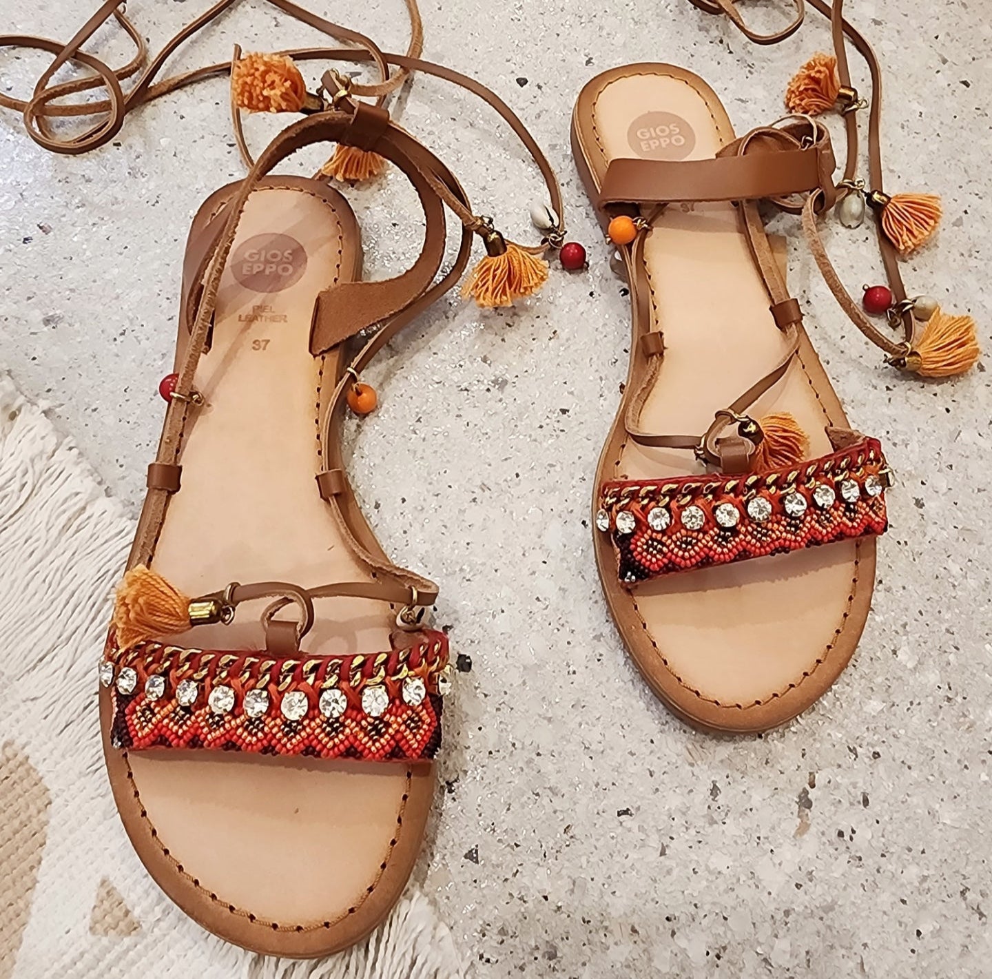 Gioseppo Ioana sandal with tan leather ties, shells, beaded embellishments and mustard-orange tassel details, top view.