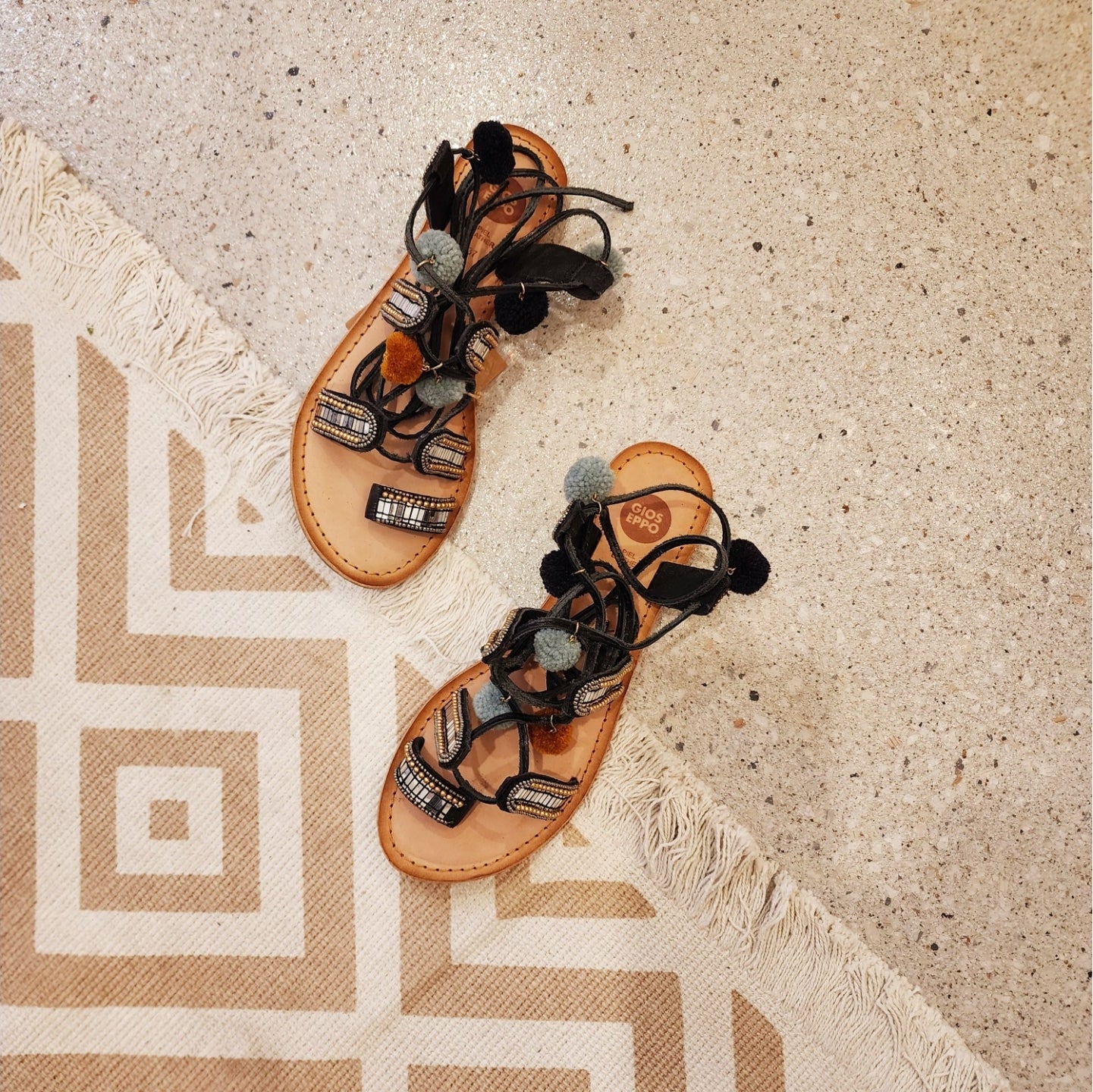 Gioseppo Nayeli sandal with mirror and pom pom details and tan leather wrap-around straps, top view.