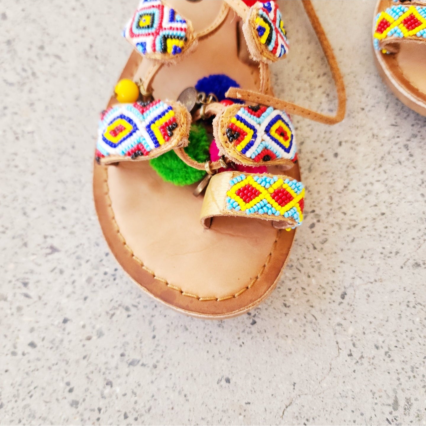 Gioseppo Omahas sandal close up showing colourful pompoms, beading and gold coin details