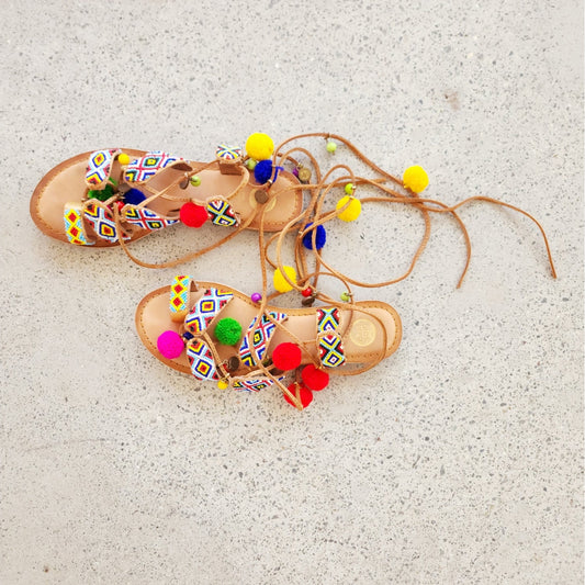 Gioseppo Omahas sandal with colourful pompoms, beading and gold coin details, lace-up ankle strap.