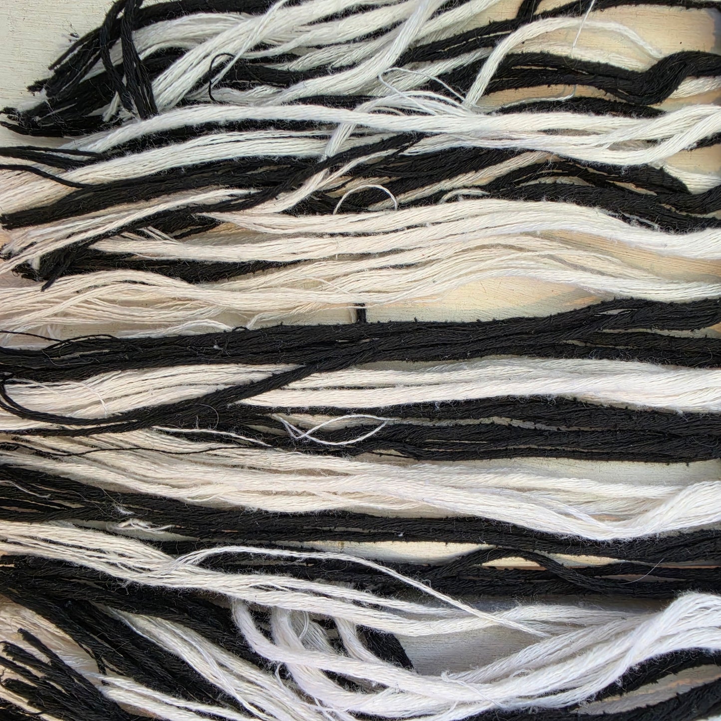Close up of the Fringe hem detail on Indi Luxe by Indikah monochrome knit dress, showing the pilling and uneven threads.