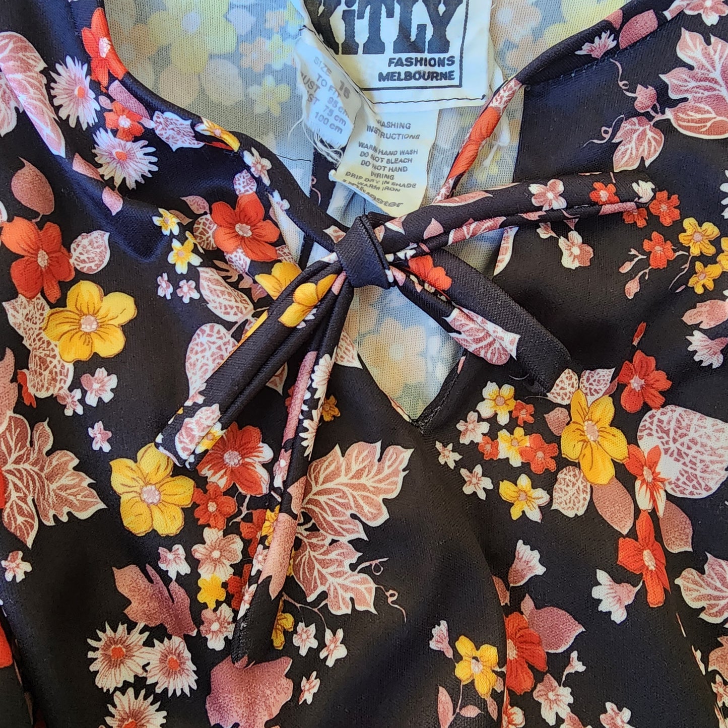 Close-up of the neckline and tie detail on the vintage Kitly floral dress.