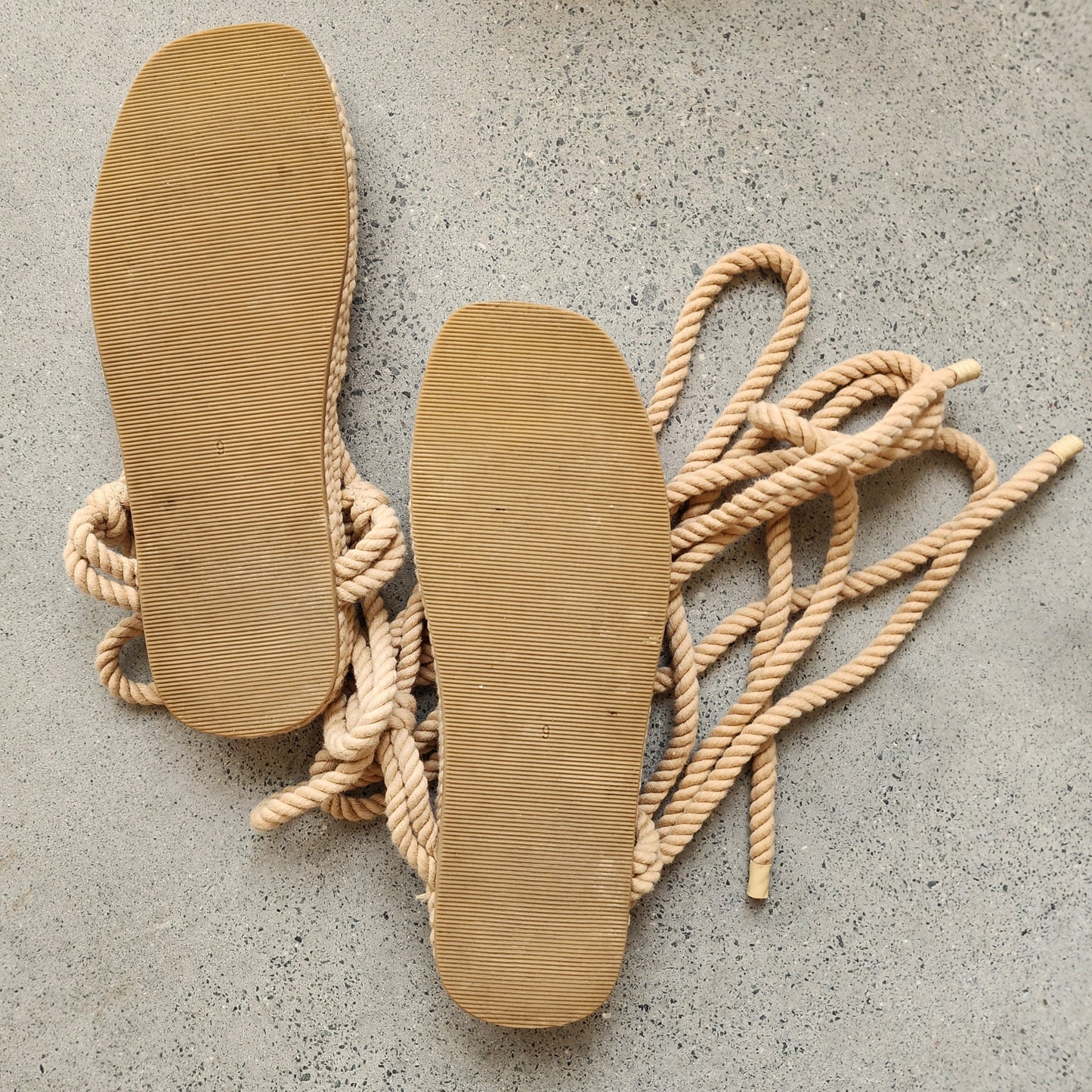 View of the outer soles of the Loeffler Randall tie sandals, showing ght e minimal wear.