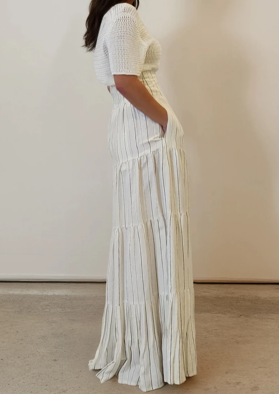 Side profile of the knit top showing relaxed fit over the shoulders and flattering drape at the waistline.