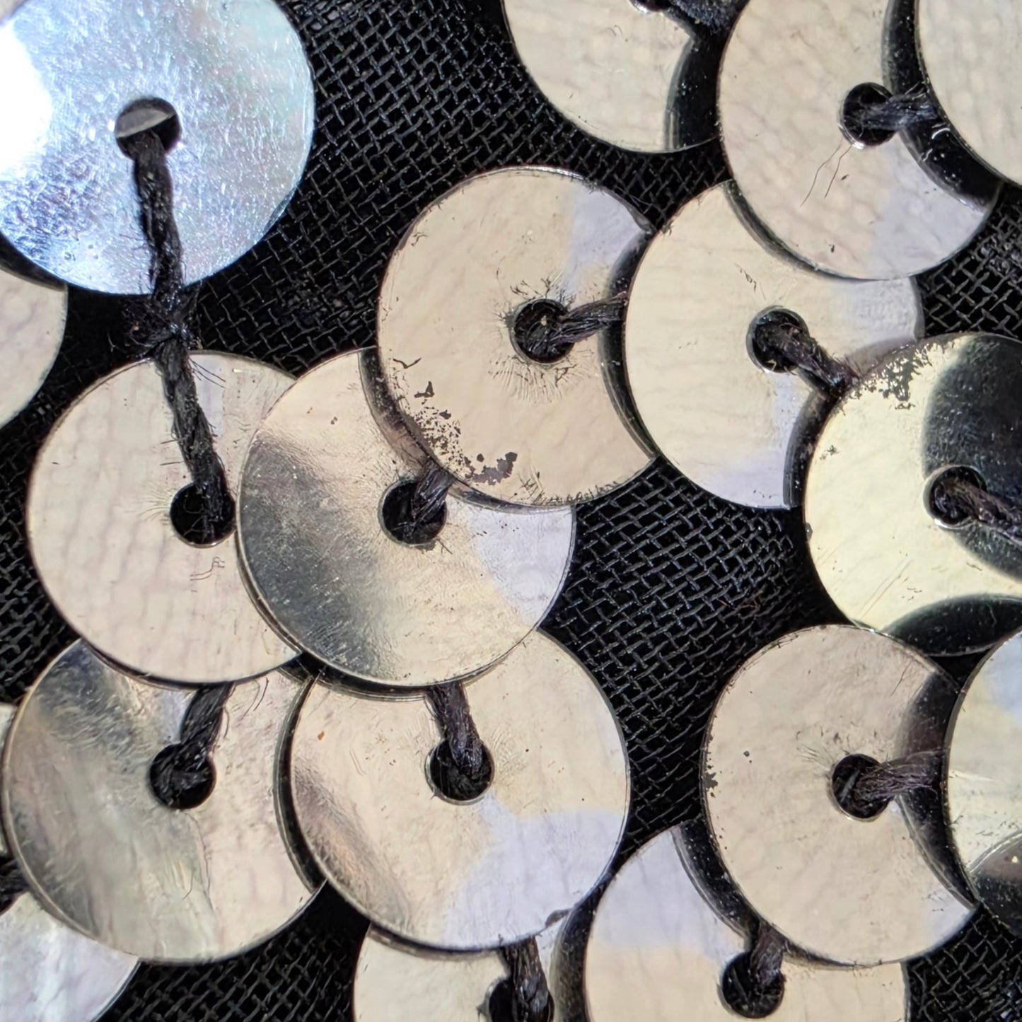 Close up of sequins detail, showing fading in places.