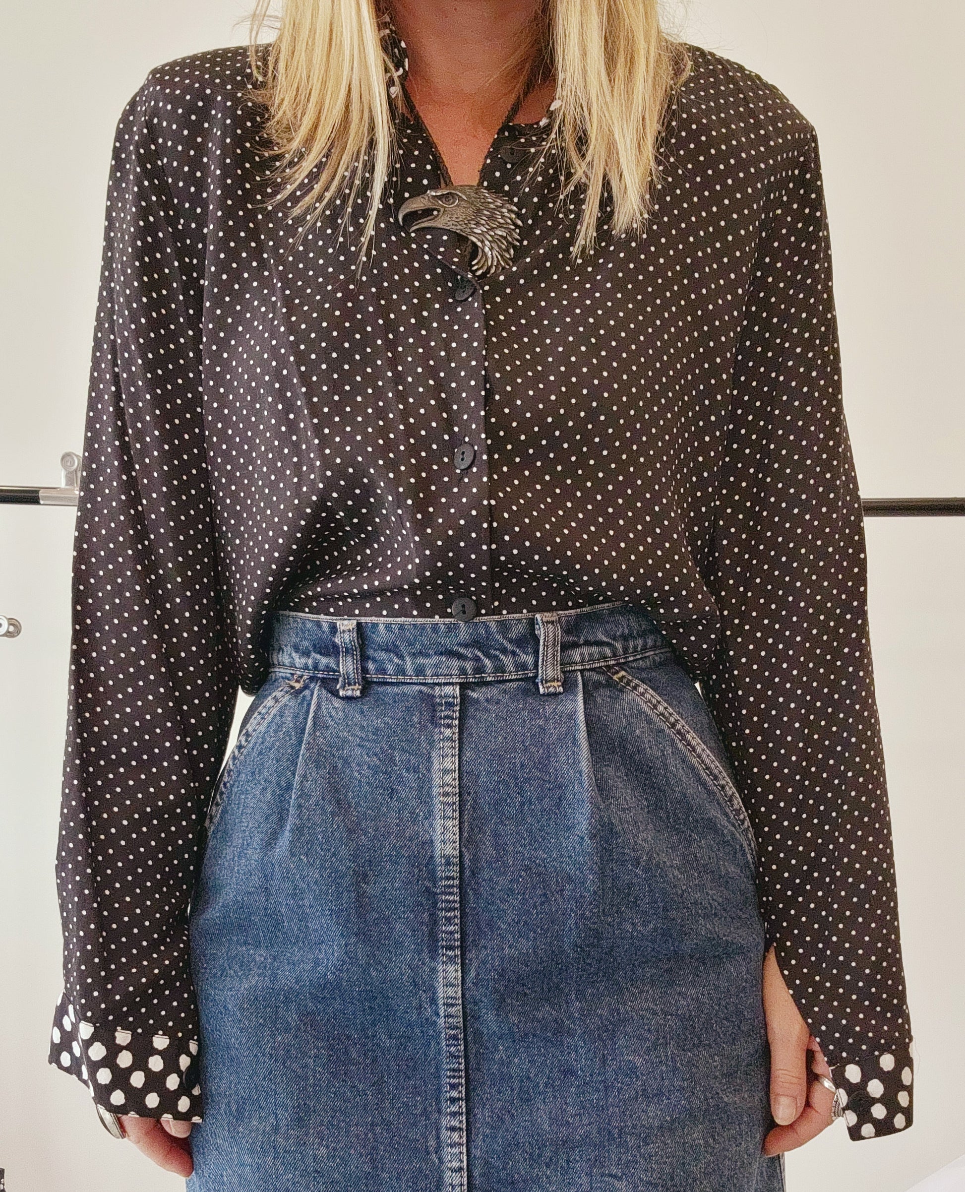 Front view of a model wearing mixed print black & white 90s button up shirt, styled with western accessories.