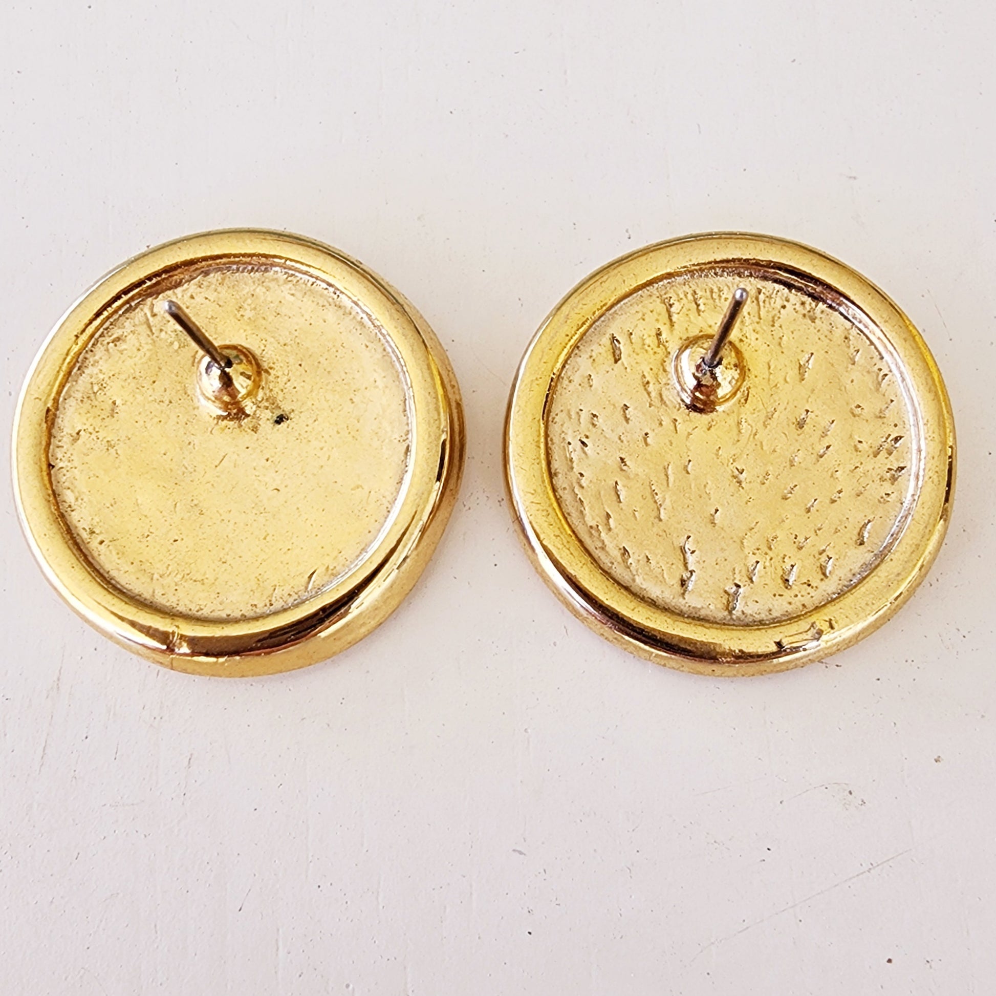 Back of round gold-plated earrings showing wear and post detail