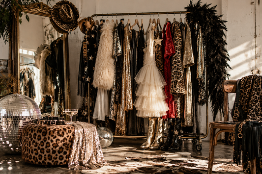 Vintage party clothing rack with sequins, leopard print, feathers and disco balls.