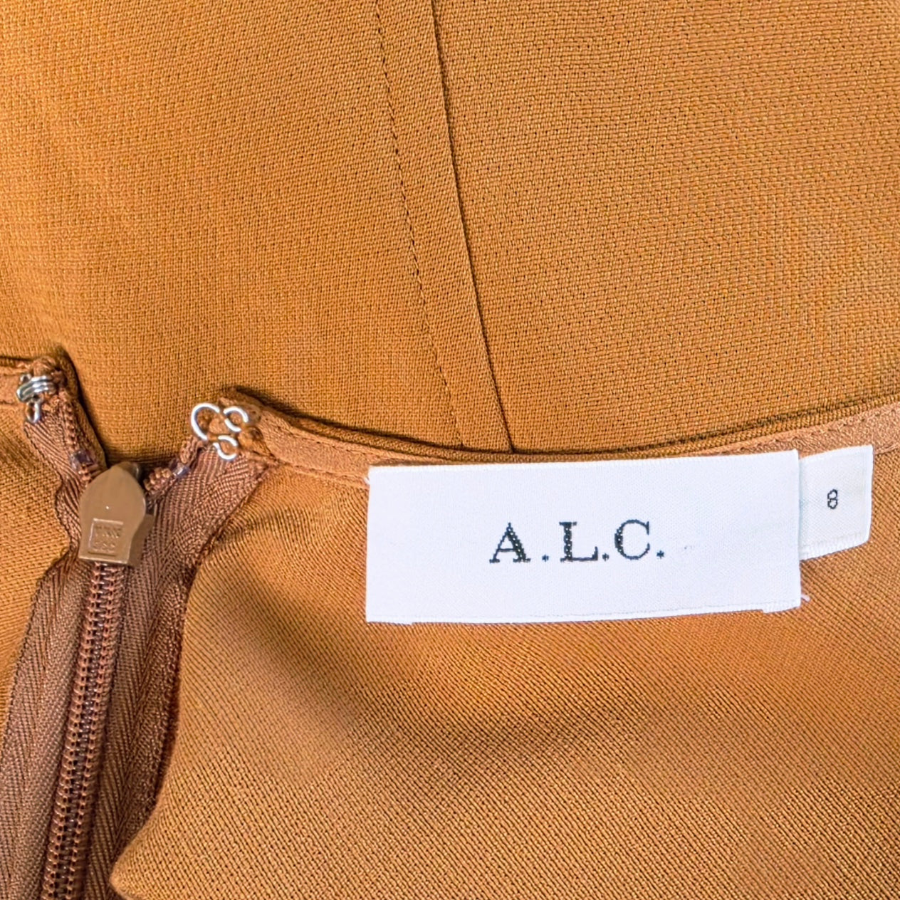 Image showing the inside brand label of the Sander Midi dress in honey.