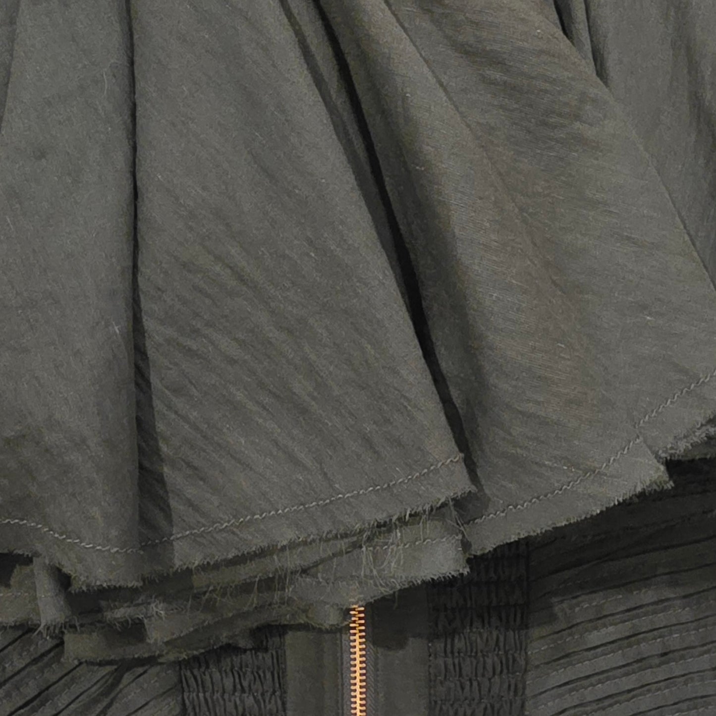Close up view showing the raw hemline on the Aje Aquiline gown.
