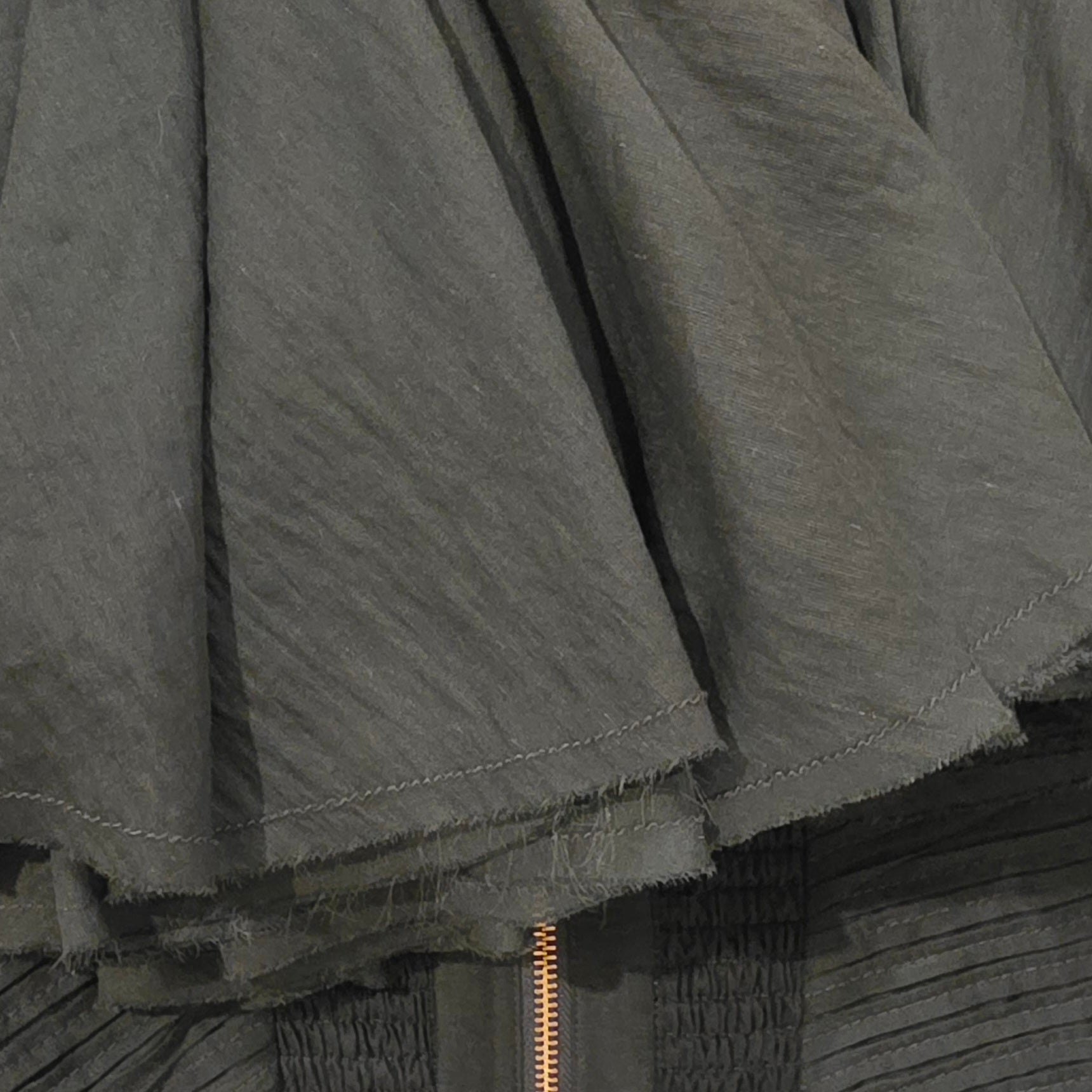 Close up view showing the raw hemline on the Aje Aquiline gown.
