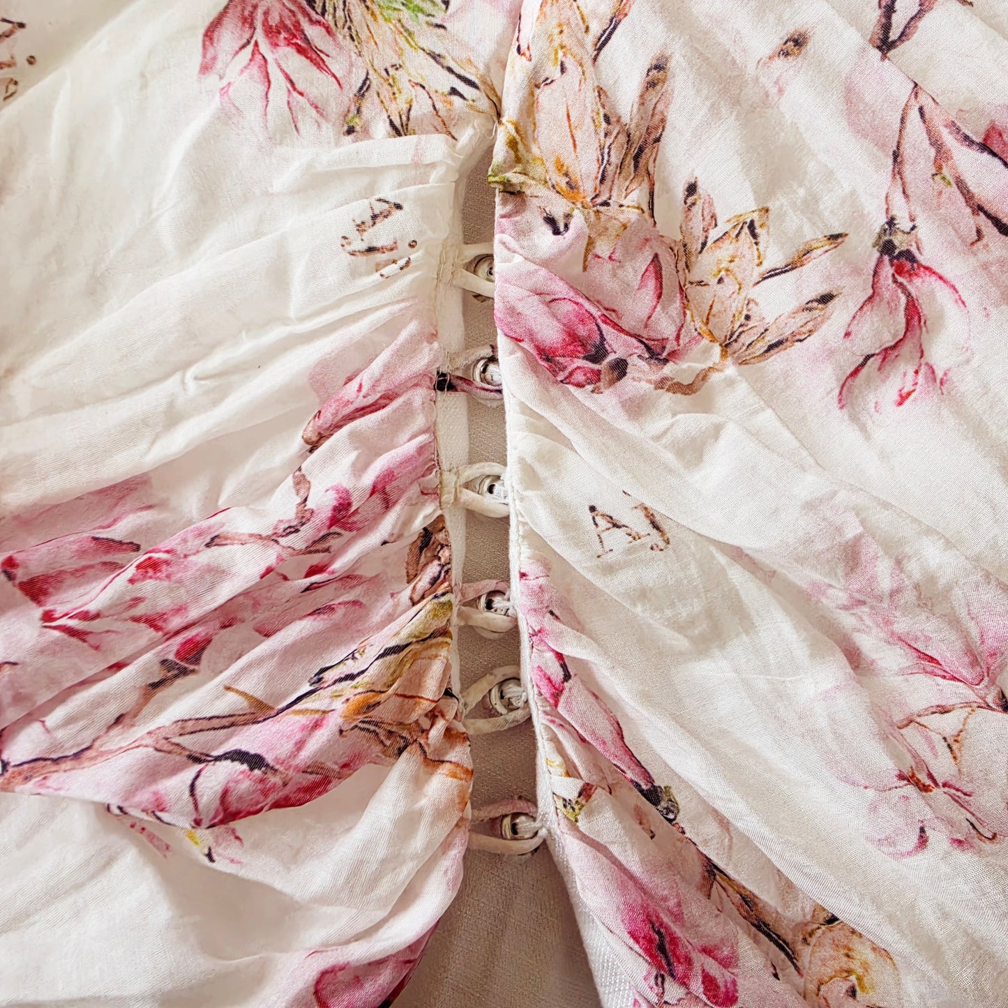 Close up of the button details at the top of the split on the Aje floral gown
