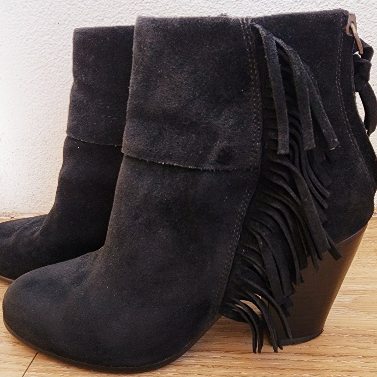 Close up, side view of the fringe suede ankle boots by Ash showing the suede texture, fringe detail and zip up back.