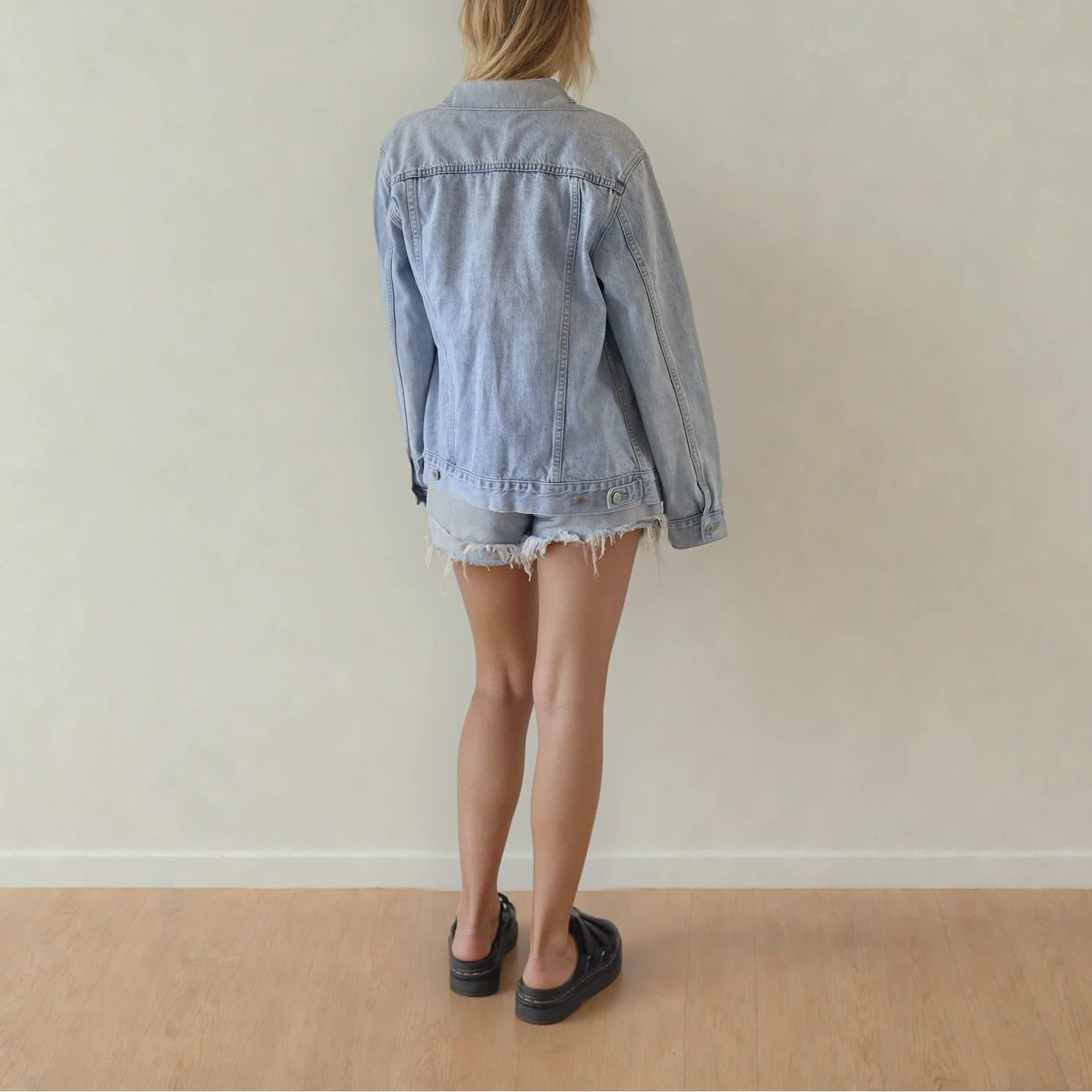 Image showing the back biew of the Assembly Label denim jacket, showing the adjustable back tabs and button wrist details.