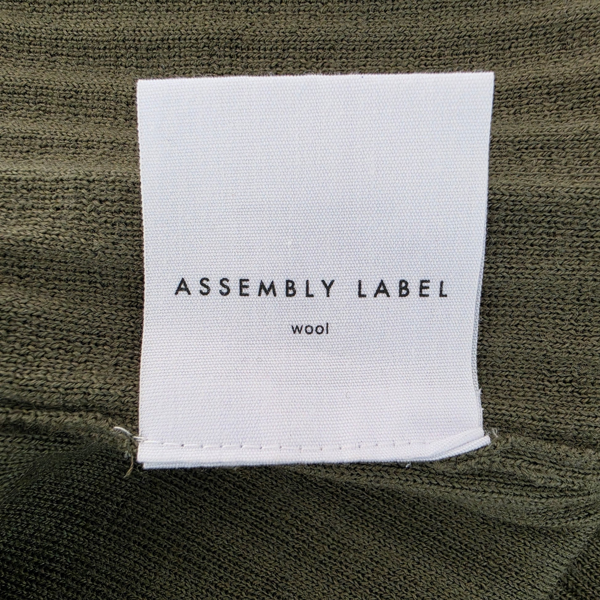 Close up view of the Assembly Label fabric label on the ribbed midi dress