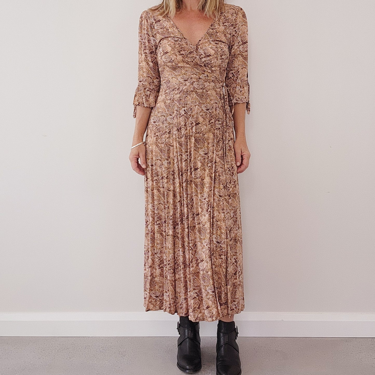 Front view of model wearing the Auguste the Label Pia wrap dress, showing the v-neck style, with wrap waist and 3/4 sleeves.