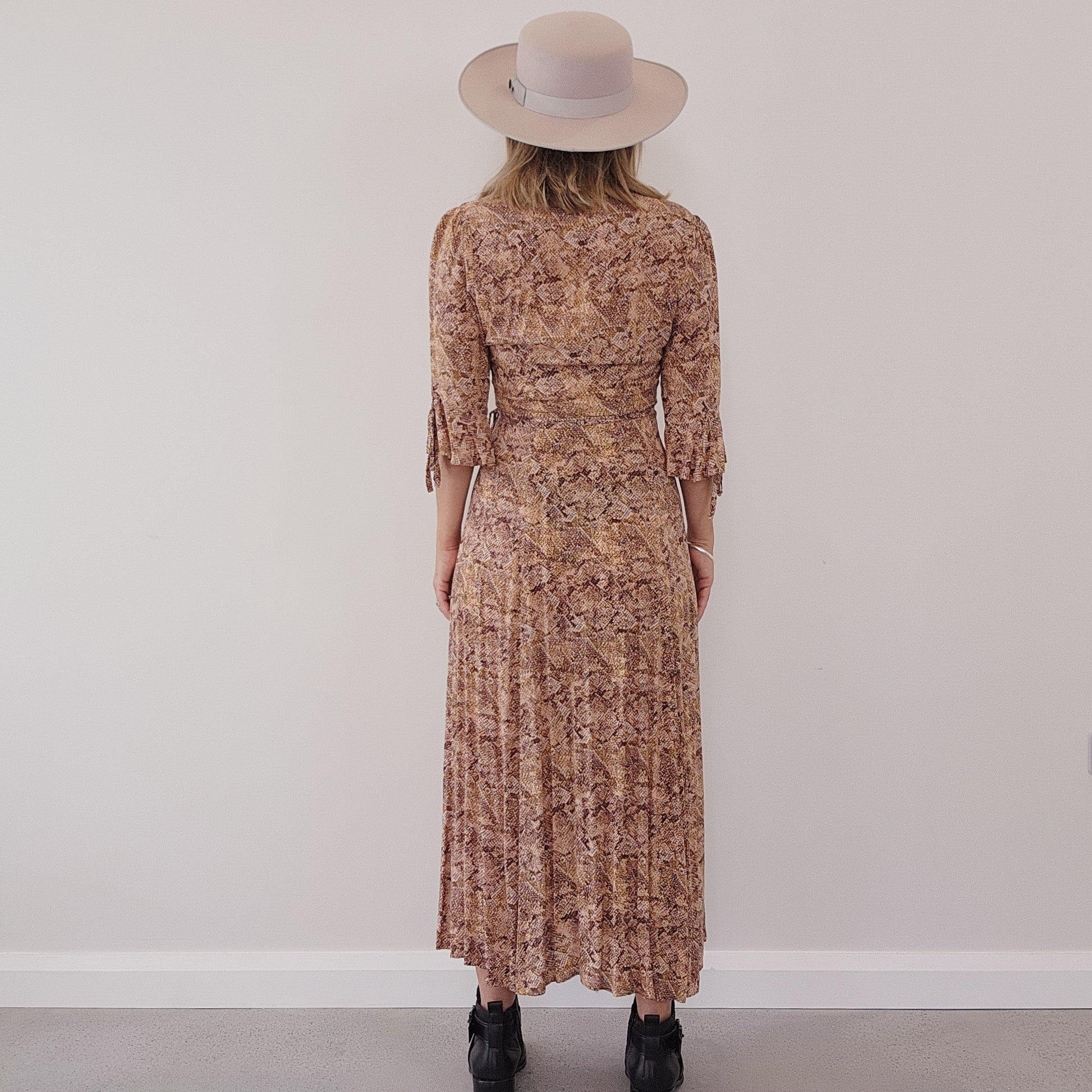 Back view of model wearing the Auguste the Label Pia wrap dress, showing he midi fall of the dress.