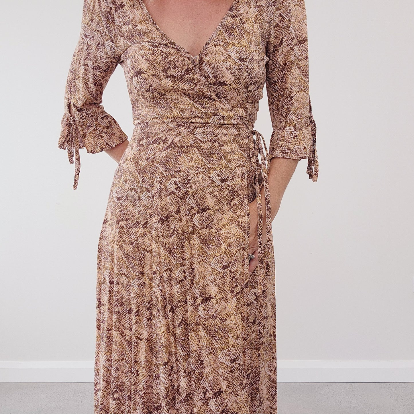 Front close-up view of the Auguste the Label snake print pia wrap dress, showing the V-neck style and tie waist.