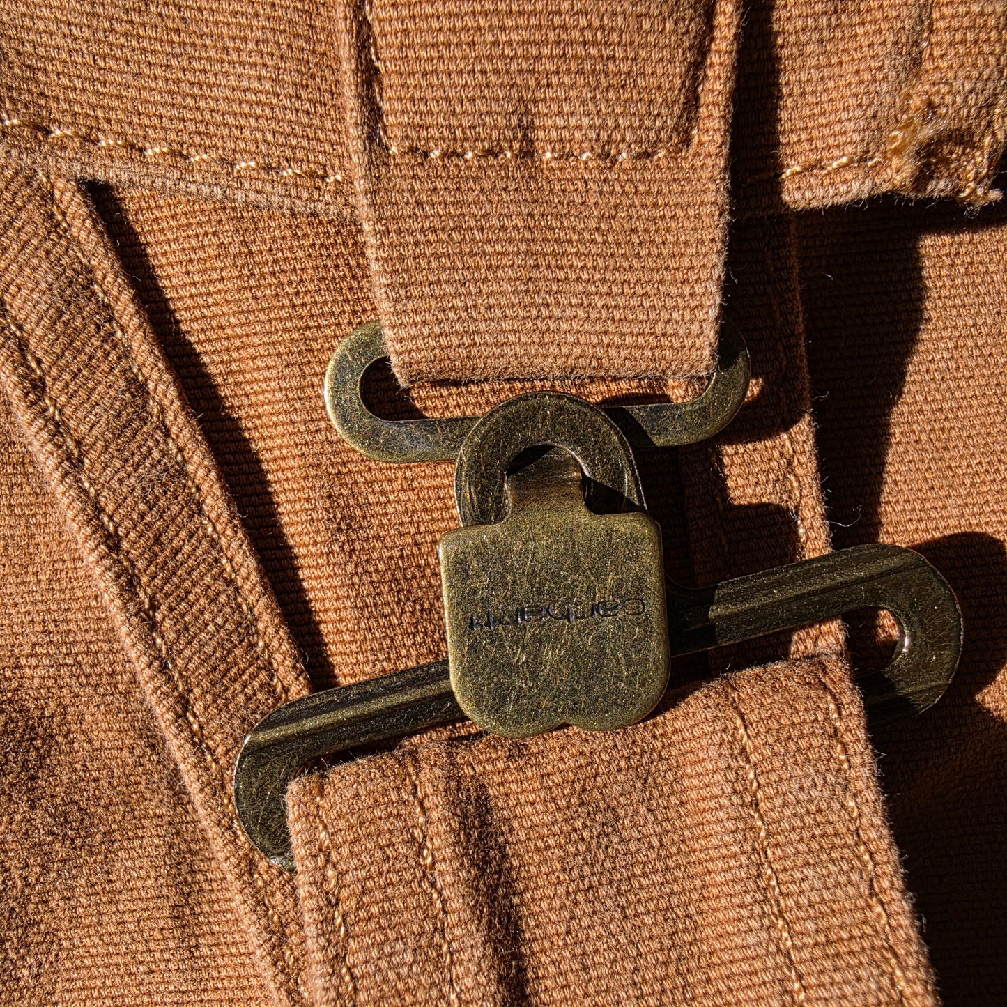 close up view of the Carhartt overall bib clips showing the engraved logo