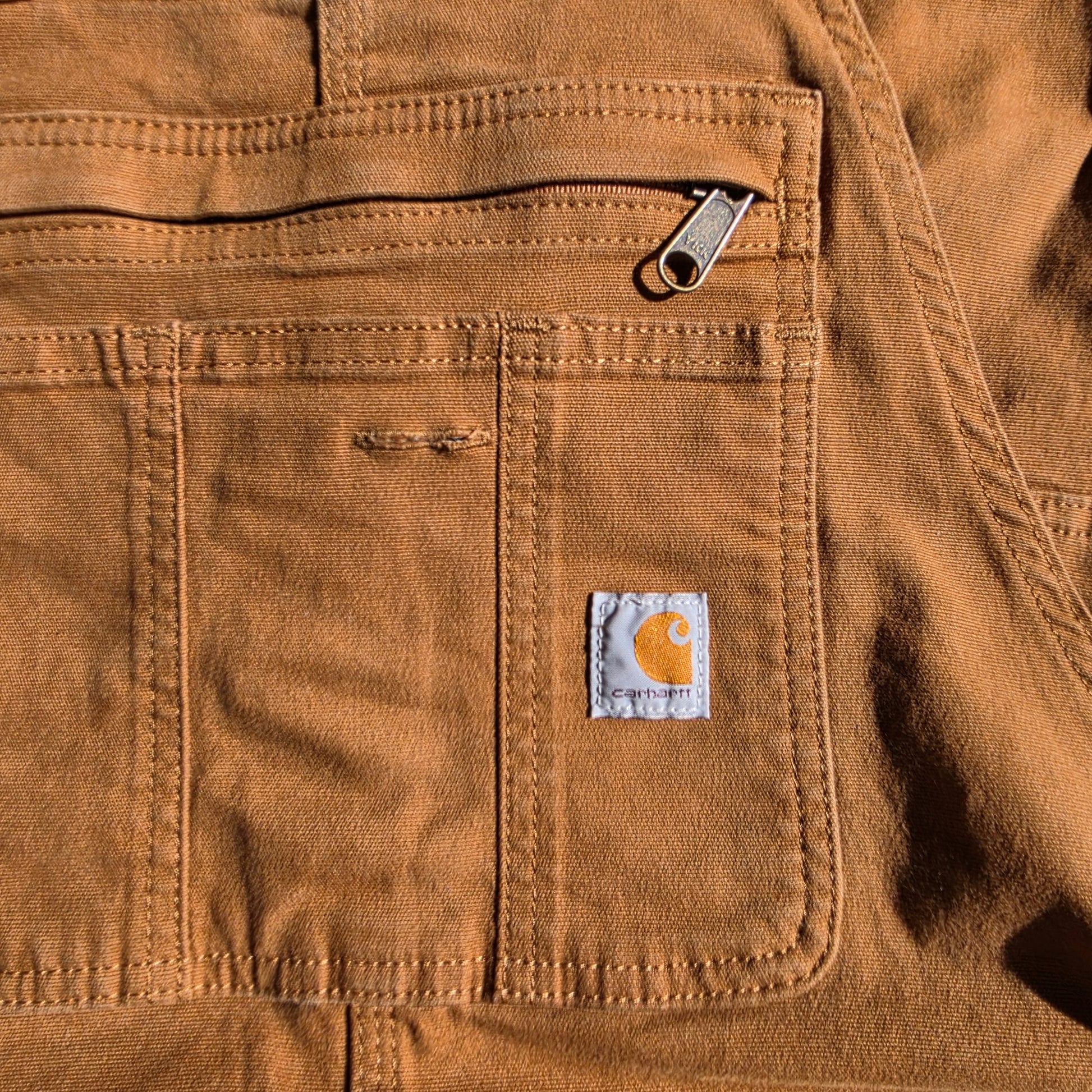Close up view of the front pocket details on the Carhartt overalls