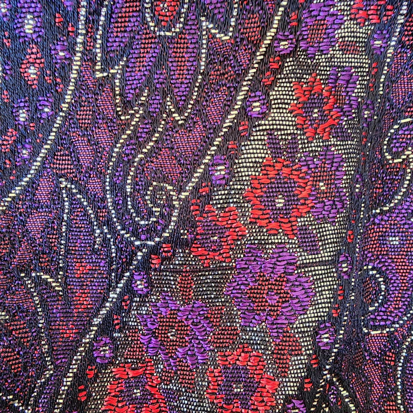 Image close up of vintage paisley blouse fabric highlighting small areas where fabric has pulls.