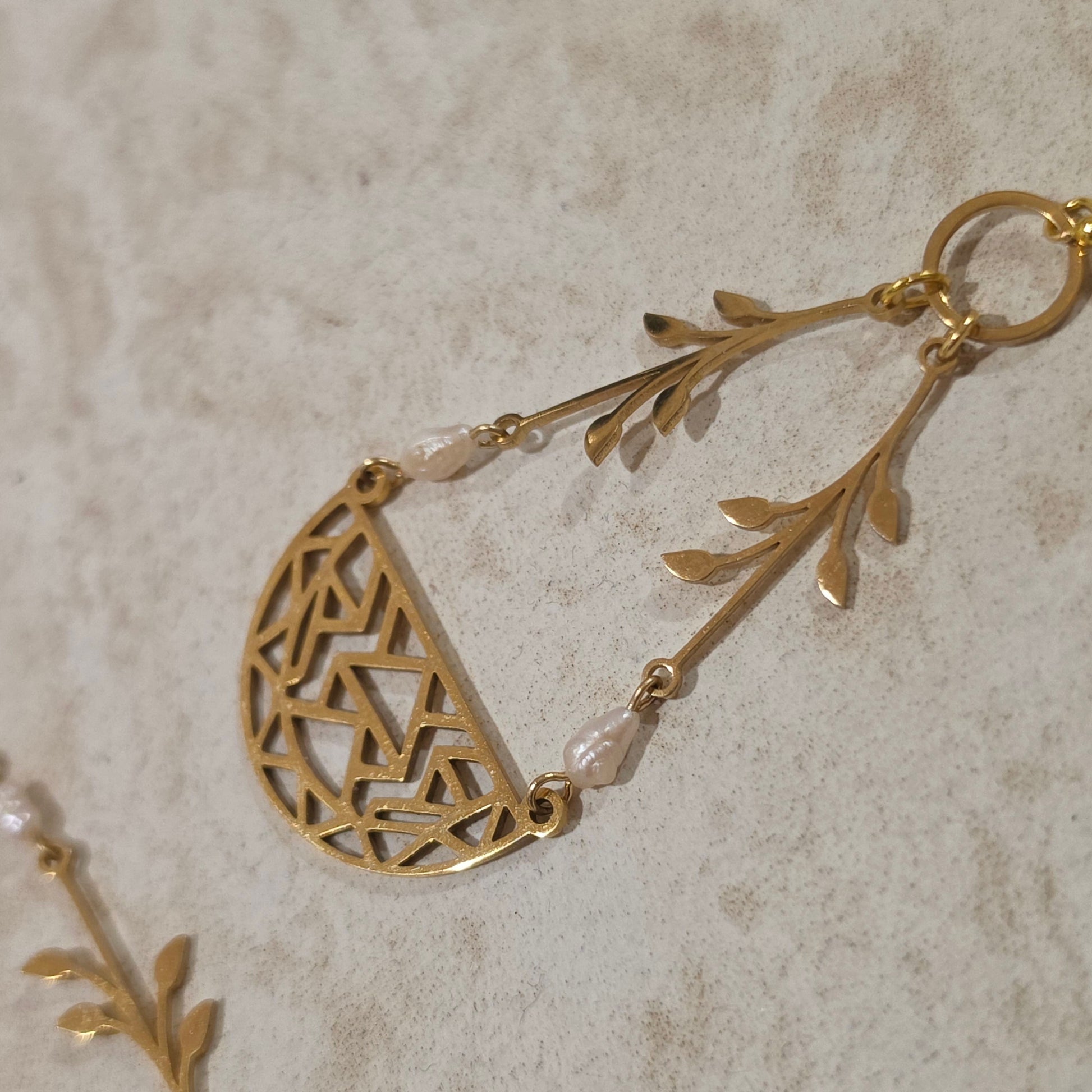 Close-up view of the Coral handmade pearl earrings, showing the unique shape and irregularities of the natural pearls reworked with gold plated stainless steel components.