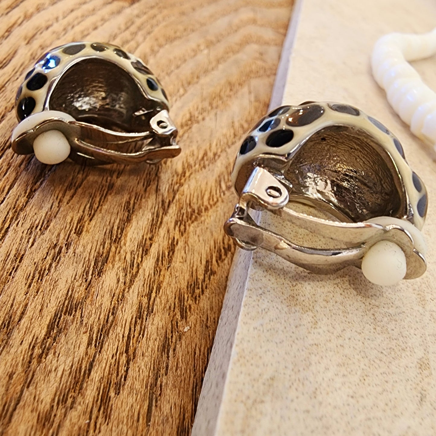 Back view of the silver enamel clip on earrings showing the clip-on style with a comfort pad.