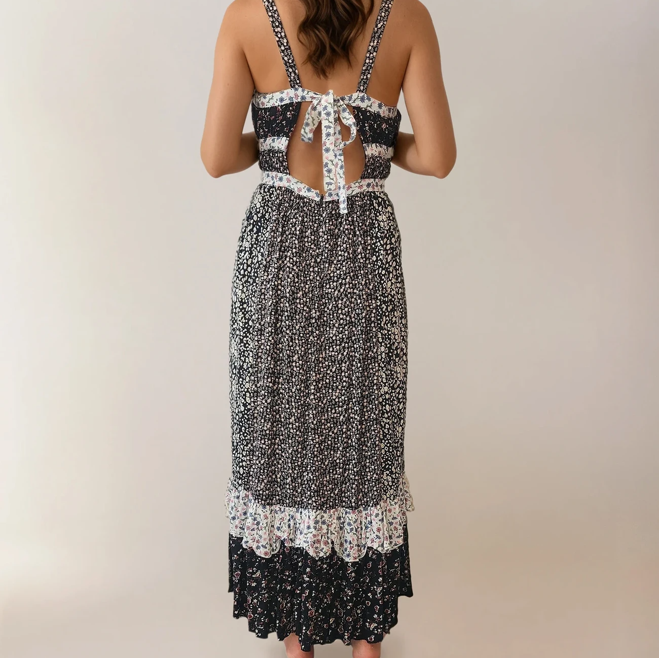 Model showing the back view of the Yesica dress, showing the mixed florals and frills and the tie up back