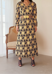 Stunning black with bold gold patterned dress. Vintage 70s with a longer sleeve and V-neck. The print has flowers and circles in gold. Available online at wilsonavenue.au