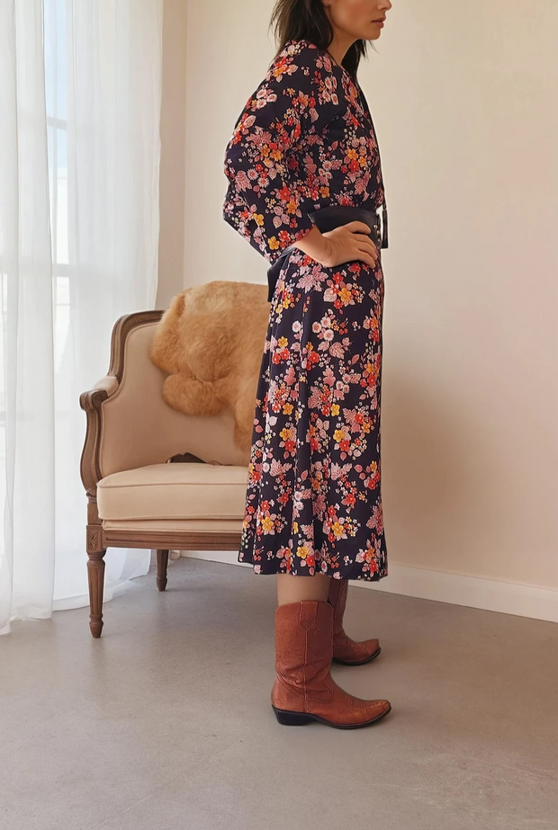 Gorgeous vintage black floral midi dress by Kitly Melbourne, this dress is in a polyester fabric, with longer sleeves and a neck tie. The floral print is scattered in in reds, yellows and dusty pinks on black. Available now online in a 16 at wilsonavenue.au