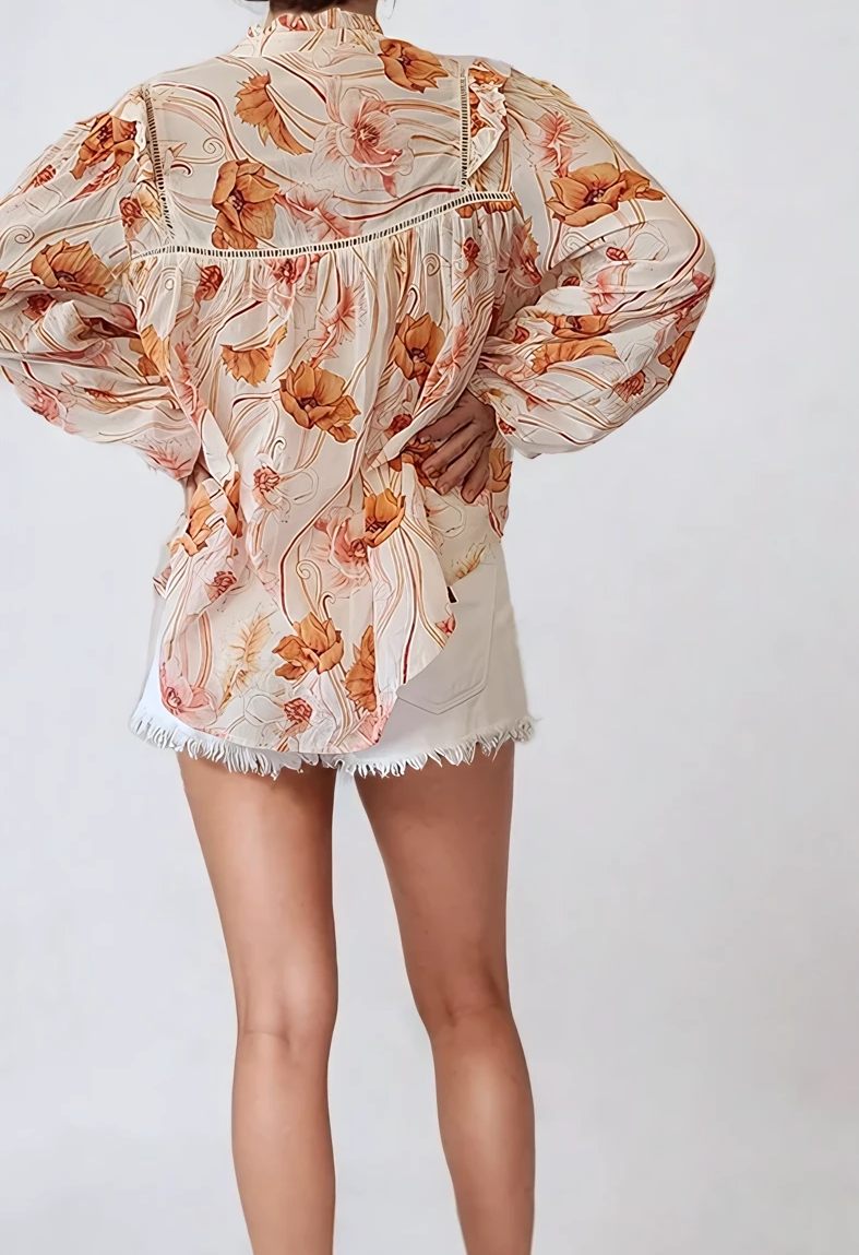Model showing the back of the Kivari Florence blouse in orange floral, showing the frills and soft drape.