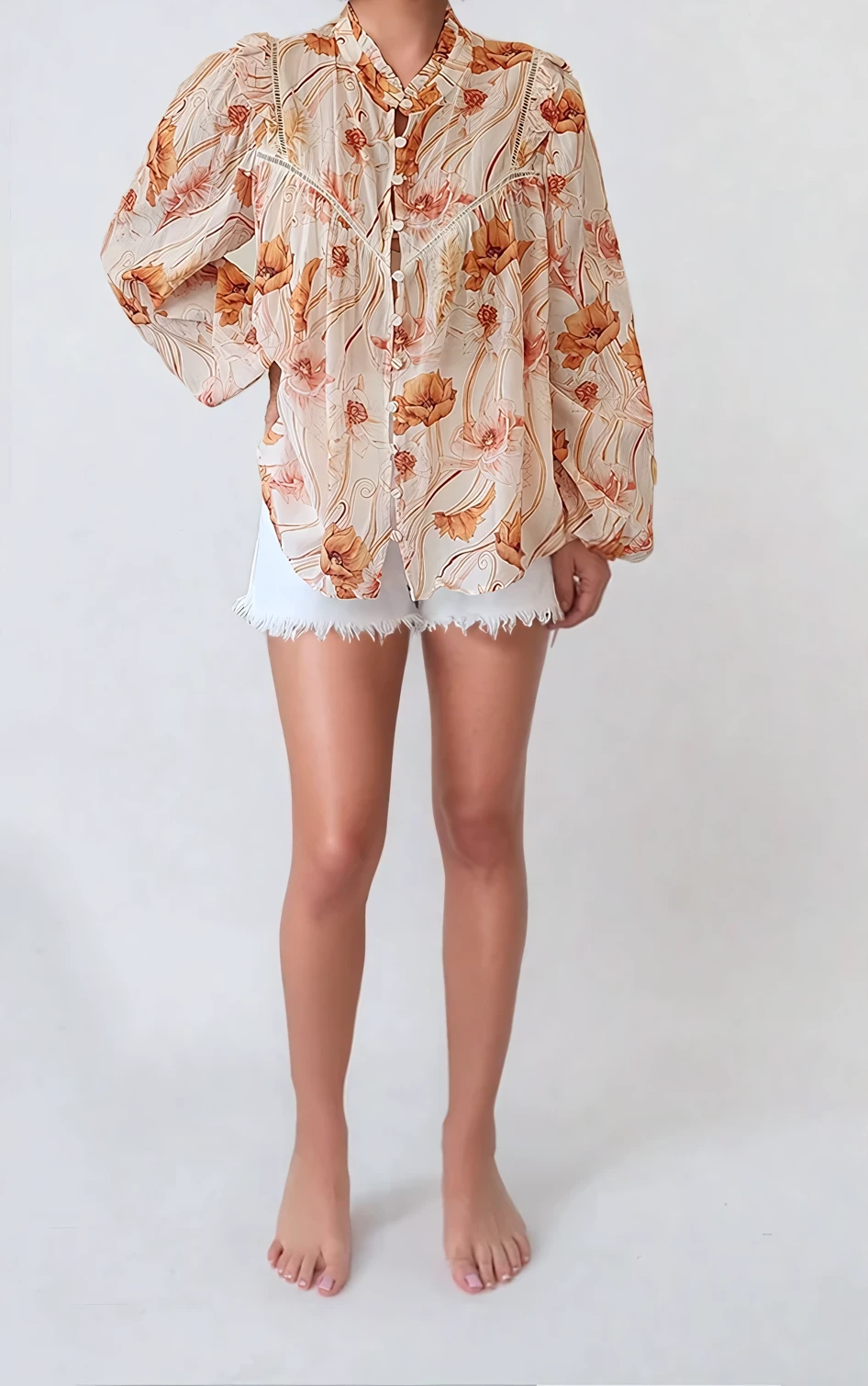Model wearing the Kivari Florence floral blouse, showing the button front detail worn with white denim shorts. 